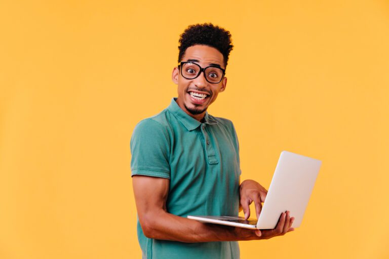 inspired-african-student-glasses-holding-white-laptop-carefree-black-male-freelancer-smiling